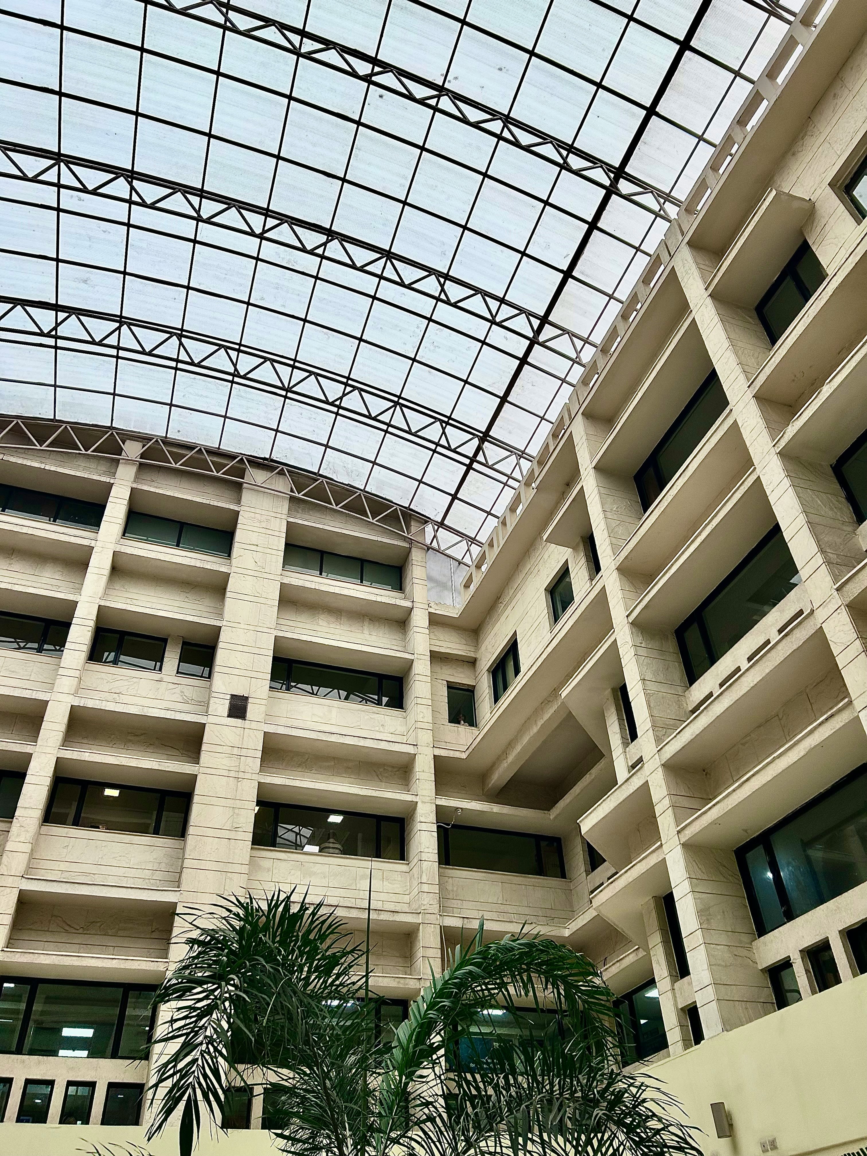 a large building with a glass roof and palm trees