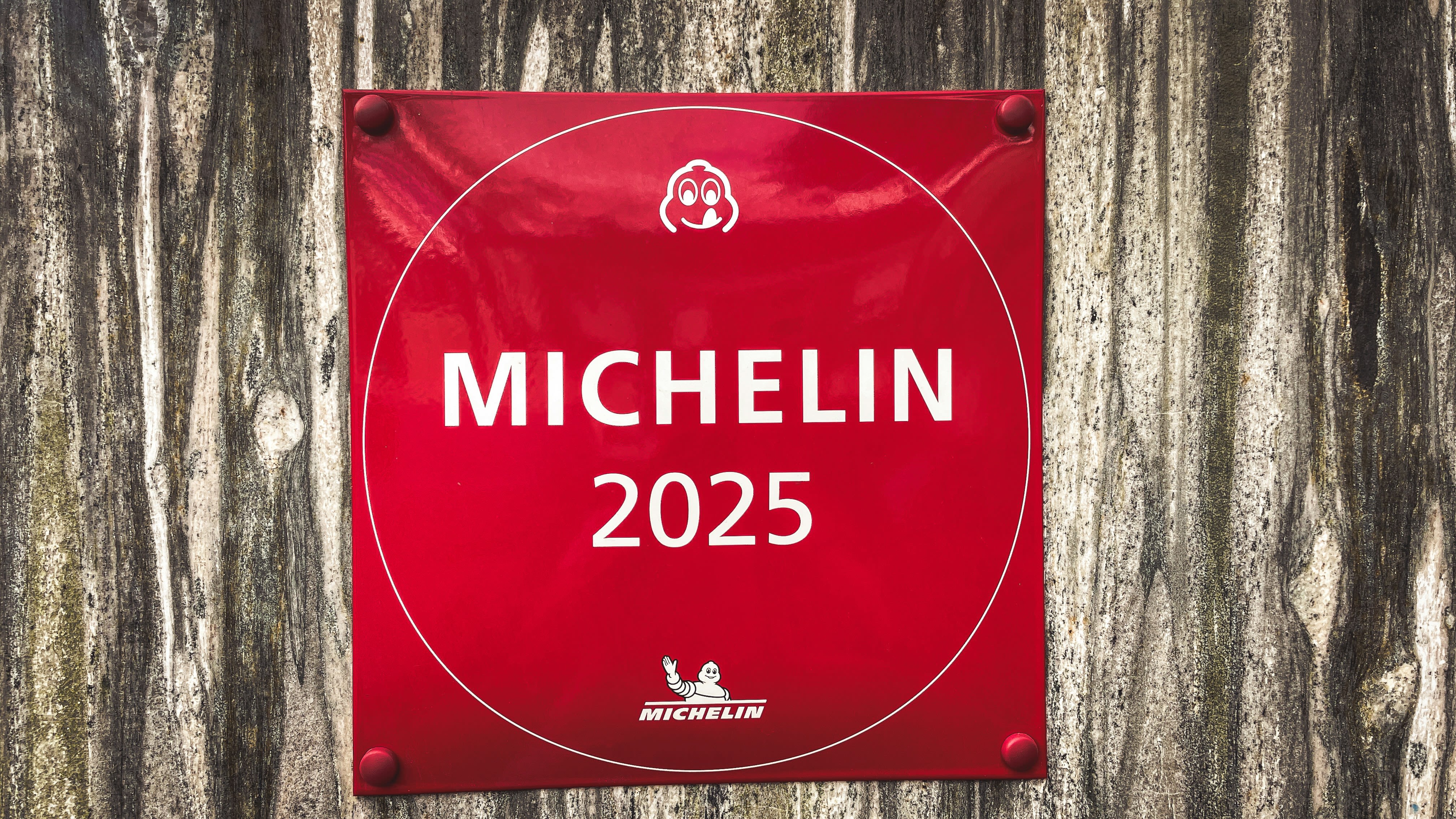 Red michelin 2025 plaque on a wooden wall