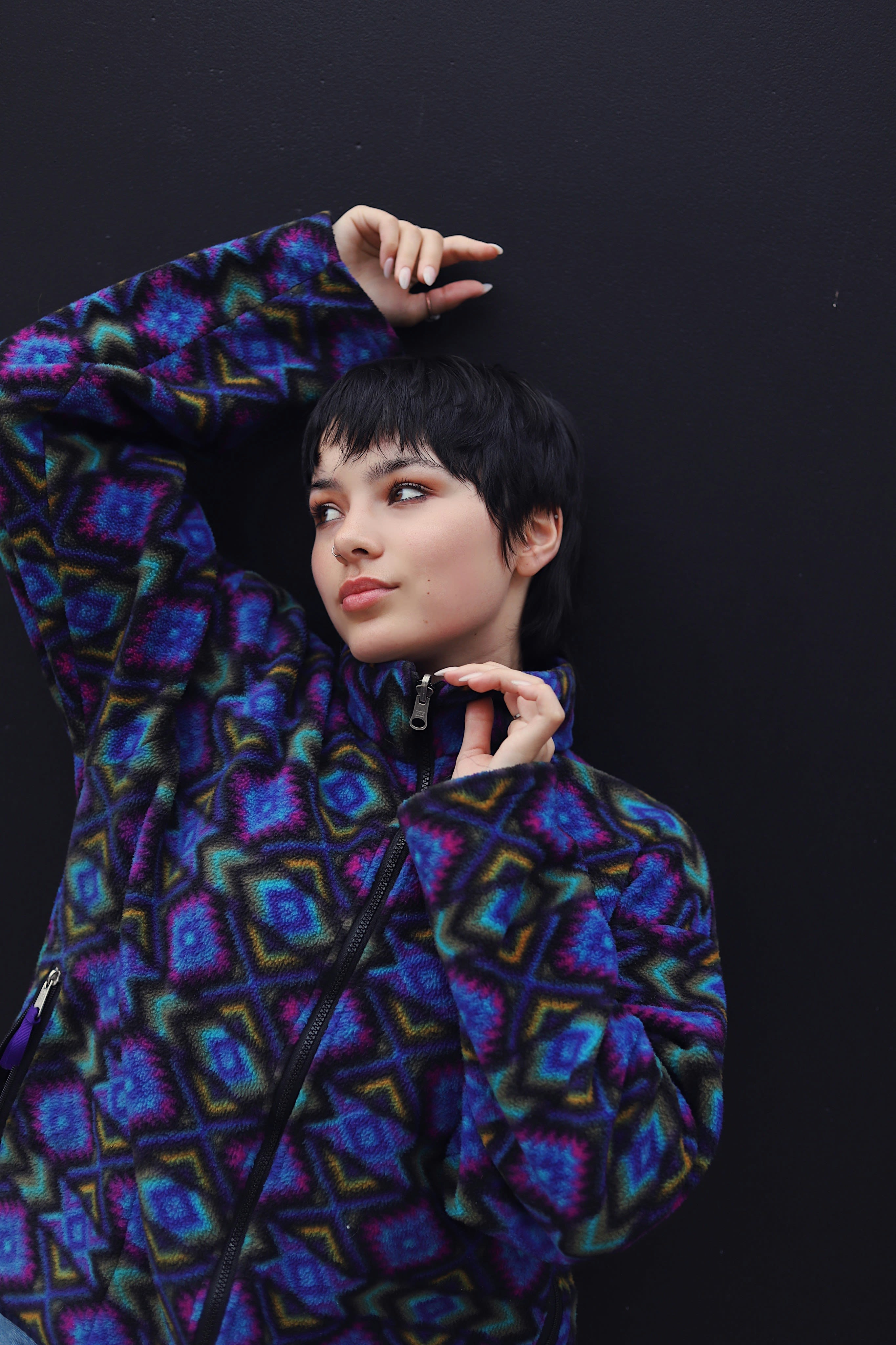 A woman in a colorful jacket posing for a picture