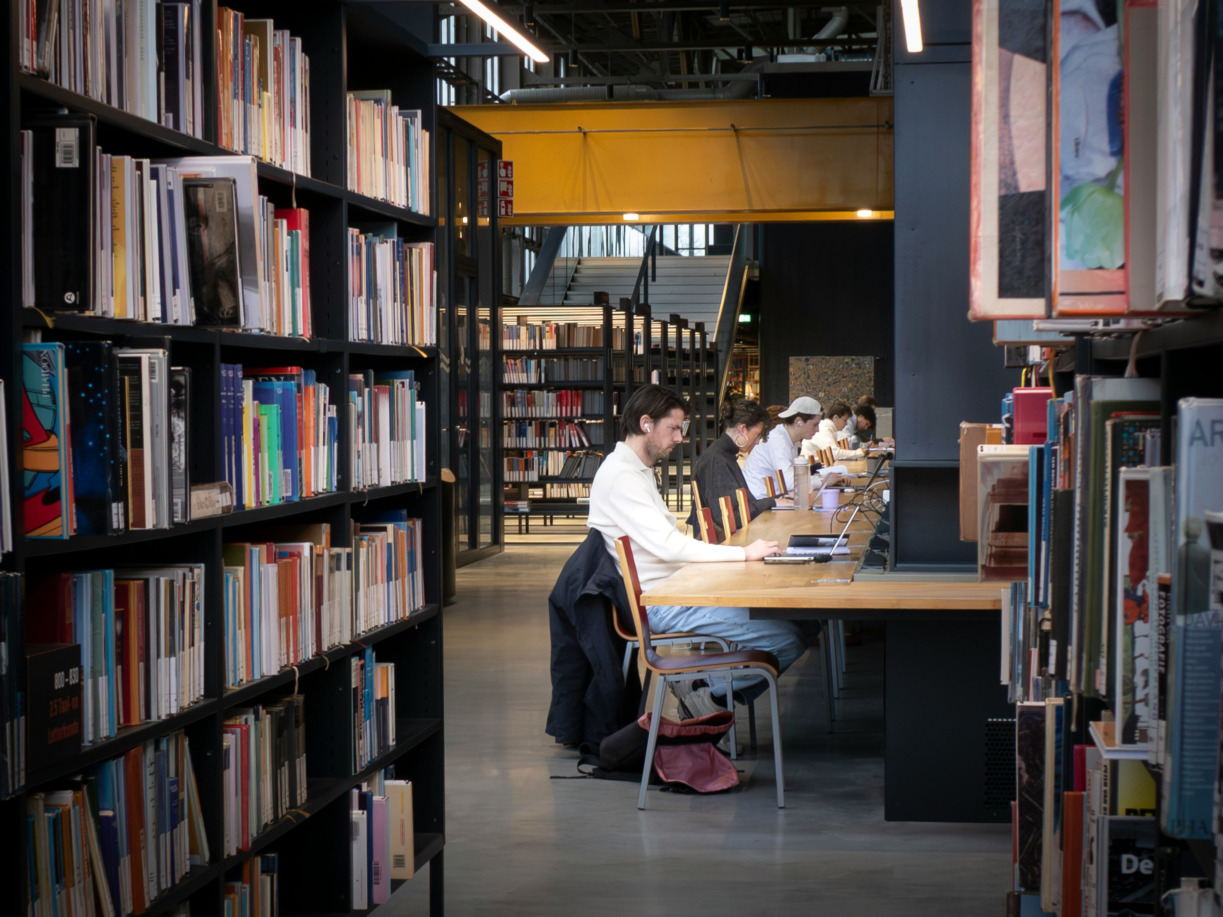 People studying at tables in a modern library